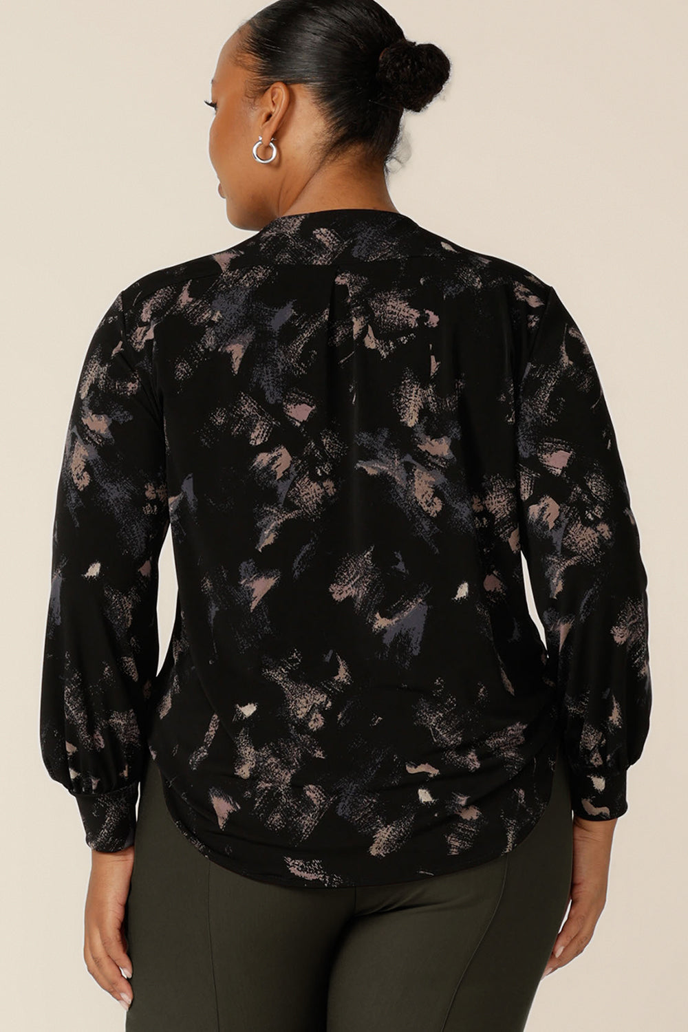 Back view of a plus size, size 18 woman wearing a long sleeve, V-neck top in printed black jersey. Made in Australia by Australian and New Zealand women's clothing label, L&F, this comfortable top is good for workwear and casual wear.