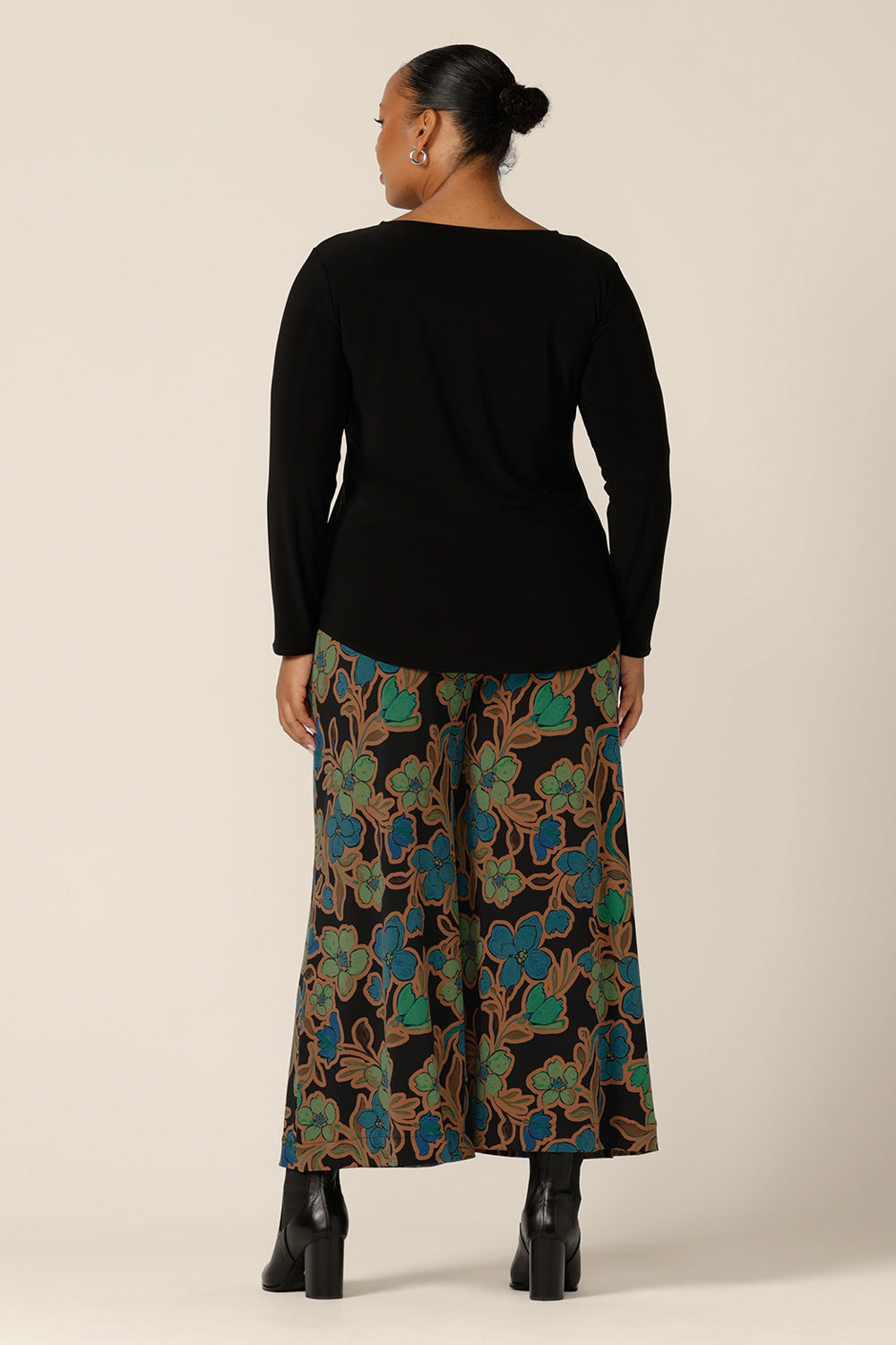 Back view of the Presley Pants in Secret Garden - a mid-rise, pull-on pant with wide legs and stretch jersey fabrication, worn with a long sleeve black top. Made in Australia by women's clothing brand L&F. Shop trousers in sizes 8 to 24 now.