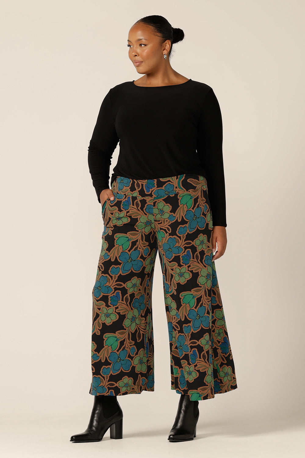 A women's, long sleeve, boat neck top in black jersey worn with wide-leg printed pants. Made in Australia by Australian and New Zealand women's clothing brand, L&F, this is a comfortable workwear top for women in petite to plus sizes.