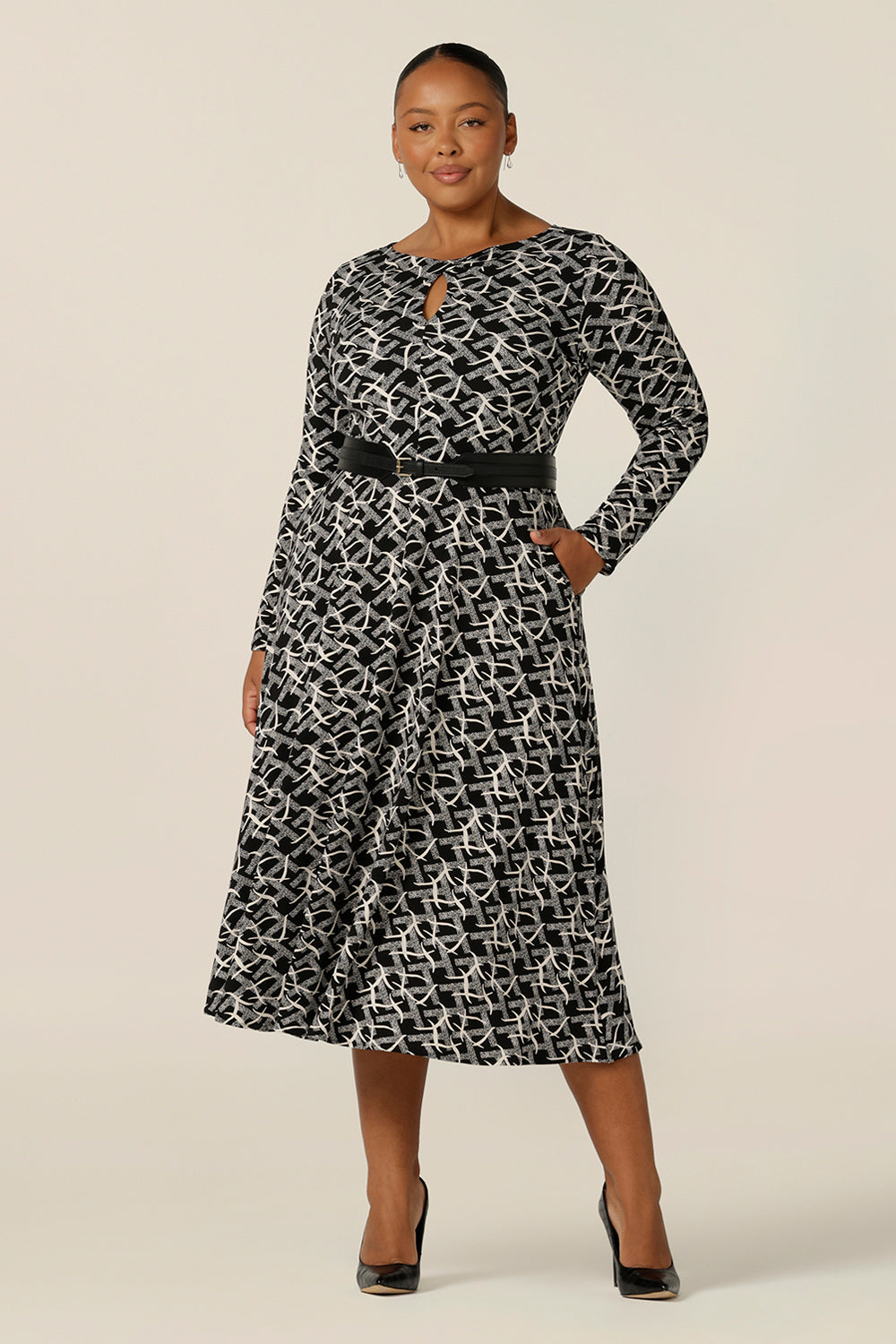 A size 18, plus size woman wears a midi length, long sleeve dress with twisted keyhole detail. Made by Australian and New Zealand women's clothing brand, L&F, shop this black and white print jersey dress in an inclusive size range of sizes 8 to 24.