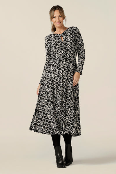 A size 10  woman wears a midi length, long sleeve dress with twisted keyhole detail. Made by Australian and New Zealand women's clothing label, L&F in an inclusive size range of sizes 8 to 24.