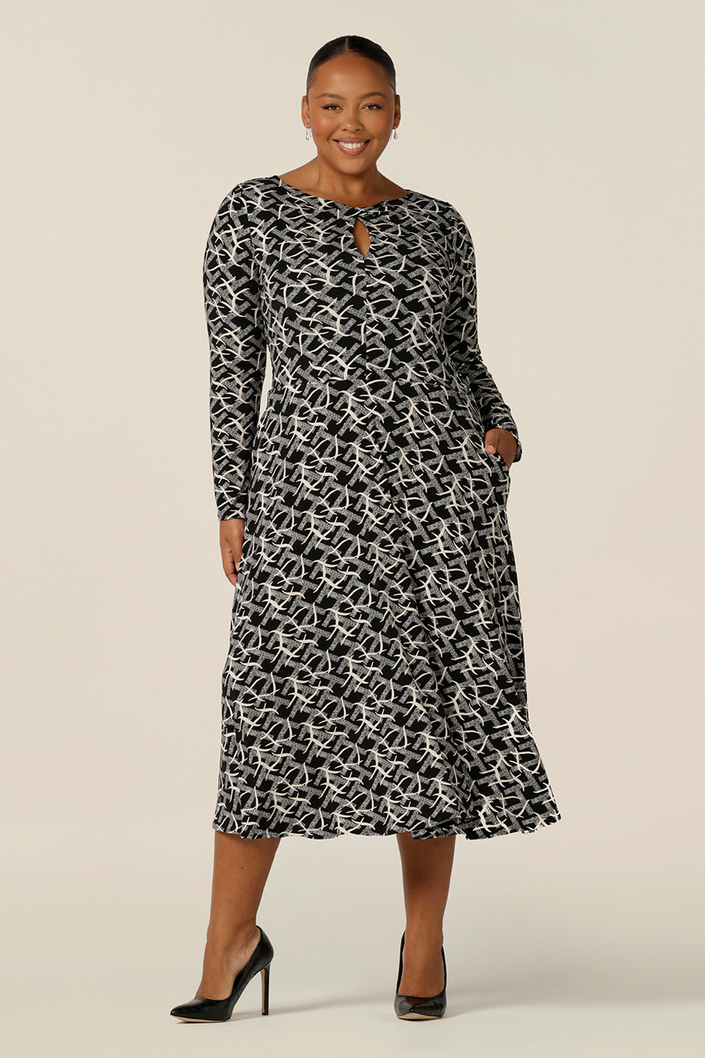 A good dress for plus size, fuller figure women, the Sandee Dress by Australian and New Zealand women's clothing label L&F is well-fitting in a black and white print, stretchy jersey fabric. A midi length, long sleeve dress with twisted keyhole detail, this is an Australian-made work dress available to buy in an inclusive size range of 8 to 24.