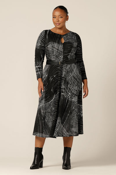 A size 18, plus size woman wears a midi length, long sleeve dress with twisted keyhole detail. Made by Australian and New Zealand women's clothing brand, L&F, shop this warm winter dress in an inclusive size range of sizes 8 to 24.