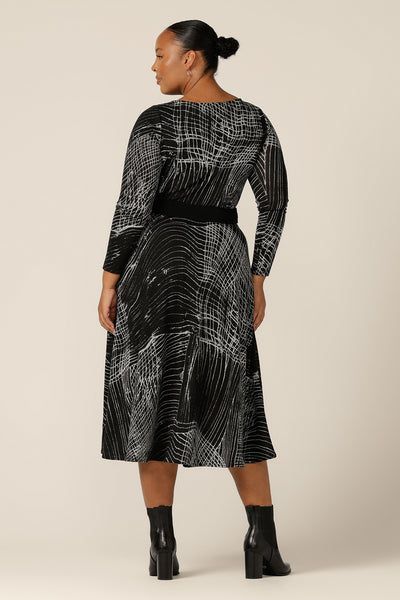 Back view of a size 18, fuller figure woman wearing a midi length, long sleeve dress with twisted keyhole detail. Made by Australian and New Zealand women's clothing label, L&F, shop this warm winter dress in an inclusive size range of sizes 8 to 24.