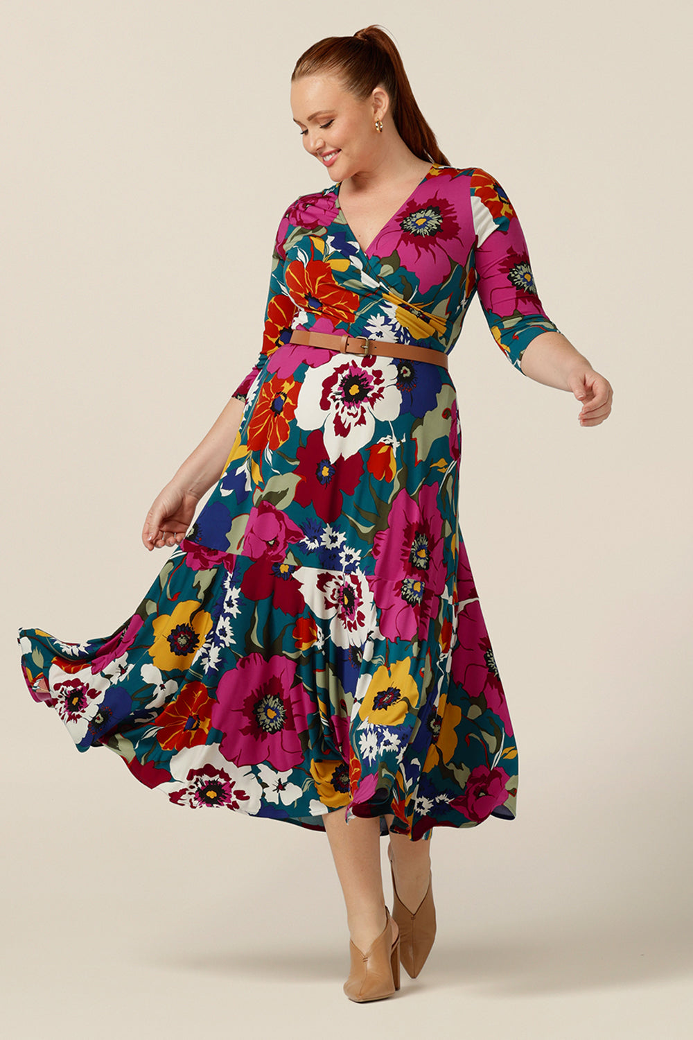 A size 12, curvy woman wears a fixed wrap dress in floral print jersey. Made in Australia by  Australian and New Zealand women's clothing label, L&F this jersey wrap dress with 3/4 sleeves is reversible and can be worn with a boat neckline. A dress for work or occasion wear, shop this maxi dress online.