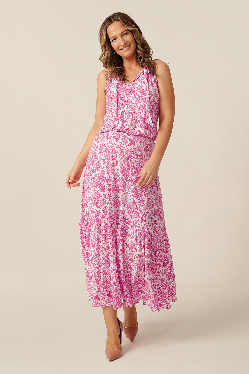 model wearing white and pink patterned maxi dress that draws in at the waist 