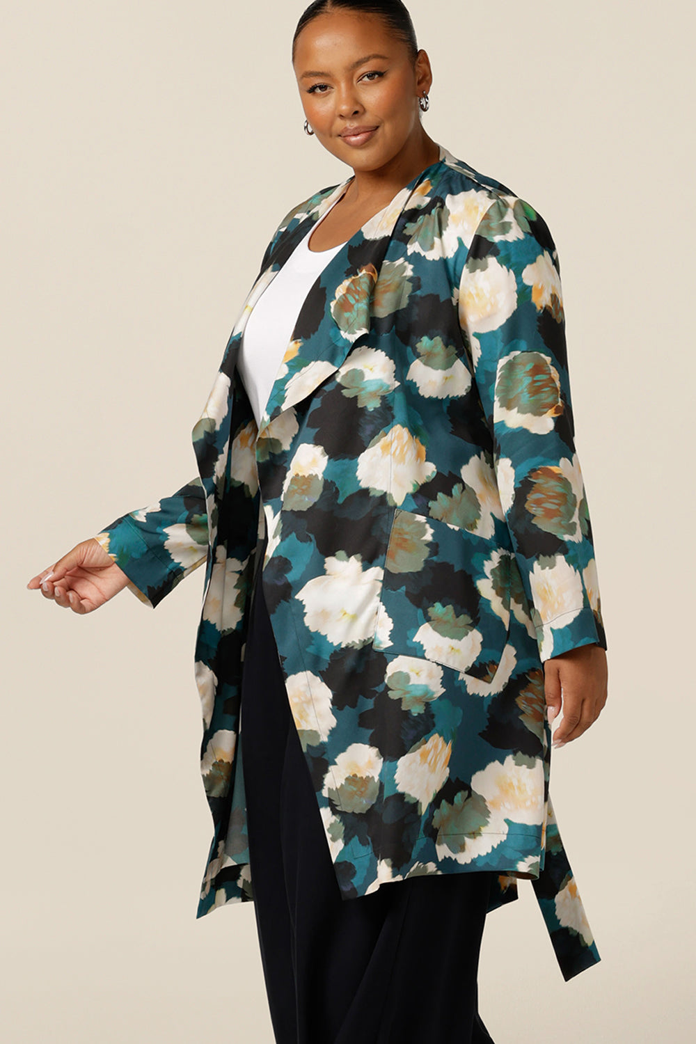 a size 18, curvy woman wears a trench coat-style jacket with waterfall front, patch pockets and belt tie. A luxury jacket, shop it in plus sizes for fuller figure online at Australian and new zealand womens clothing brand, leina and fleur. 
