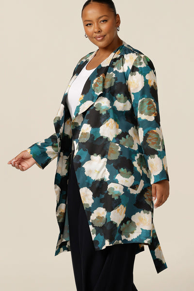 a size 18, curvy woman wears a trench coat-style jacket with waterfall front, patch pockets and belt tie. A luxury jacket, shop it in plus sizes for fuller figure online at Australian and new zealand womens clothing brand, leina and fleur. 