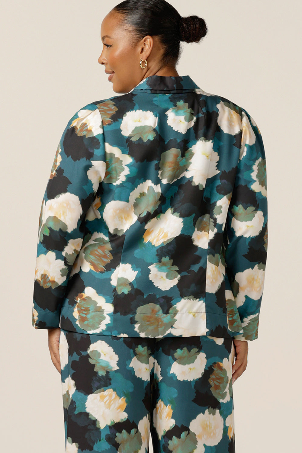 a size 18, curvy woman wears the best jacket for autumn/winter 2023. In sustainable Tencel fabric, this jacket's floral print (designed exclusively for Australian-made women's clothing company L&F) is on a teal base with white and navy flowers. A luxury jacket, shop work wear jackets in plus sizes for fuller figure online at leina and fleur. 