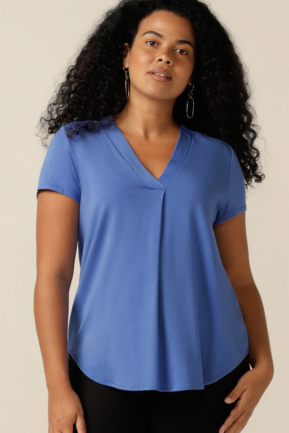 A curvy size 12 woman wears a short-sleeved V-neck top in bamboo jersey. Lightweight, breathable and made from natural fibres, bamboo jersey makes for a comfortable and cool jersey top. In sustainable fibres, this bamboo jersey top was made in Australia by Leina and Fleur, just 2 of the ways L&F is working towards producing more eco-conscious, sustainable fashion.  