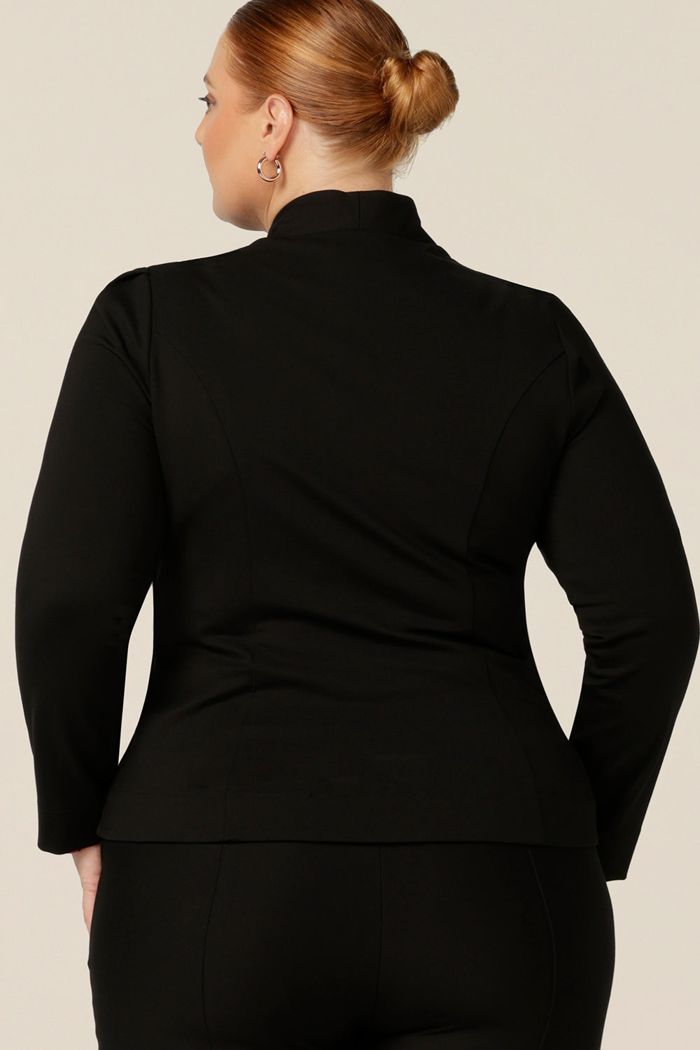 Back view of a size 18, fuller figure woman wearing a soft tailored black jacket with black workwear pants. Made in Australia for petite to plus sizes, the stretch ponte jersey is well-fitting on womanly curves. 