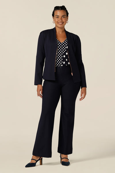 Shop this modern corporate look for women - a collarless, navy blue, tailored jacket is worn with navy bootcut leg pants. The jacket has full length sleeves, a rose gold zip fastening and is made in Australia by women's clothing label, elarroyoenterprises.