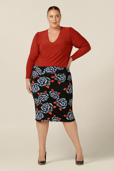 A great skirt for work and corporate wear, the Andi Skirt in Ikebana is a tube skirt in stretch jersey fabric. Australian-made by Australia and New Zealand women's clothing brand, L&F, this black skirt has a blue and orange floral patter and is worn with a long sleeve, V-neck top in orange. Shop this skirt in an inclusive size range of 8-24.