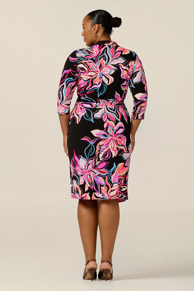 A bold corporate wear dress, the Jett wrap dress with its 3/4 sleeves, V-neck collar and fitted knee length skirt, comes in a vibrant floral print in colours of pink, peach and blue. Designed in an inclusive size range by Australian and New Zealand women's clothing label, L&F, this jersey wrap dress is worn by a size 18 as a comfortable workwear dress.