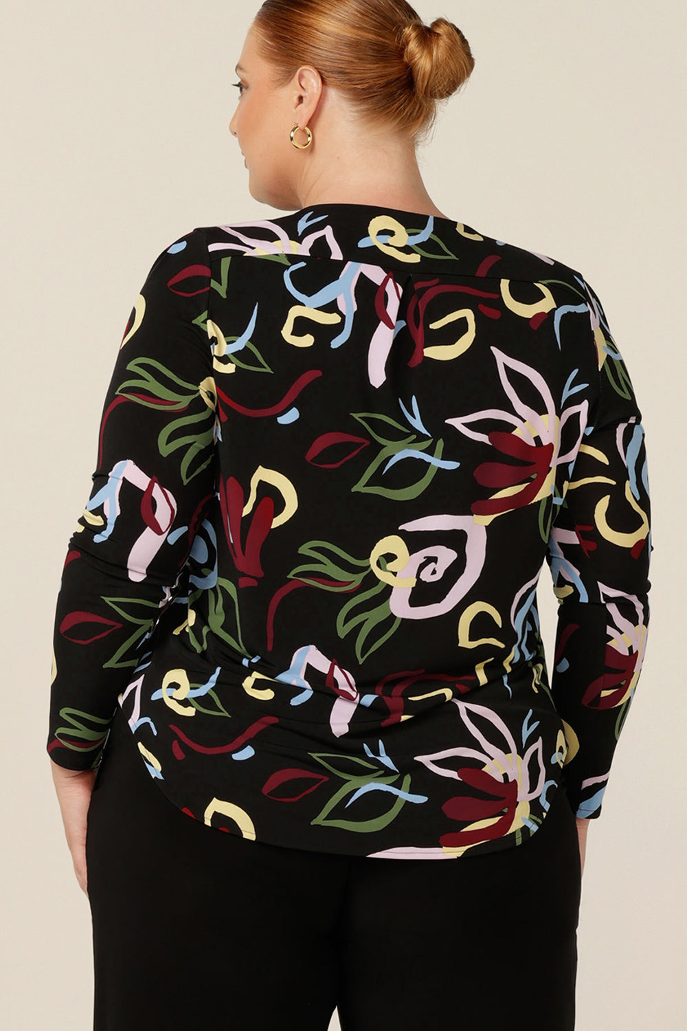 Back view of a round neck, long sleeve work top for plus size and fuller figure women. In an abstract print with black base, this comfortable top is made in Australia in an inclusive 8-24 size range.