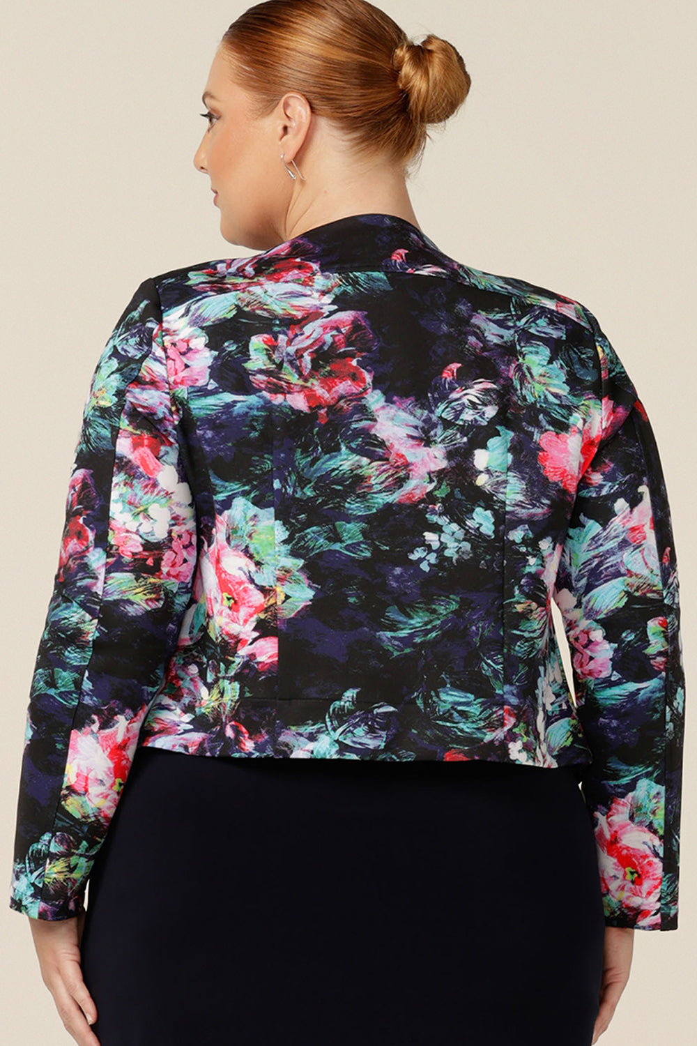 Back view of a collarless, open front jacket in a size 18. A feminine workwear jacket, this soft tailoring jacket comes in printed scuba jersey. Made in Australia for the women of Australia and New Zealand.