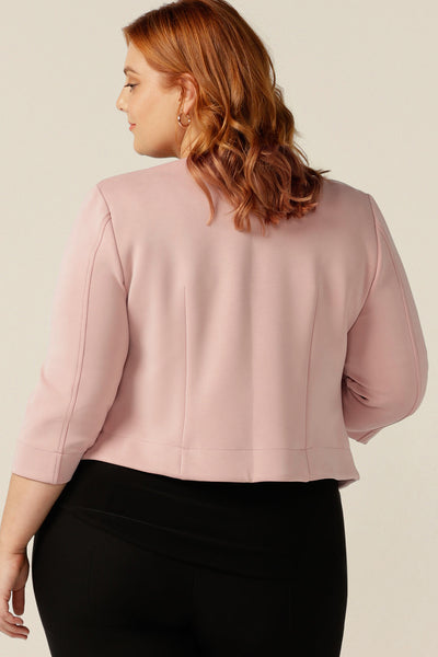 a size 18, plus size woman wears a collarless, open-front pink jacket with 3/4 sleeves. Made in Australia from stretch modal, a sustainable natural fibre, this is an eco-conscious quality corporate jacket. 