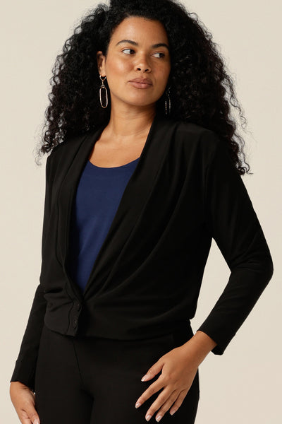 a curvy size 12 woman wears a black V-neck jacardi with long sleeves. Half jacket/half cardigan this hybrid cover-up lets women shop autumn/winter jackets that transition as cover-ups for cool weather.