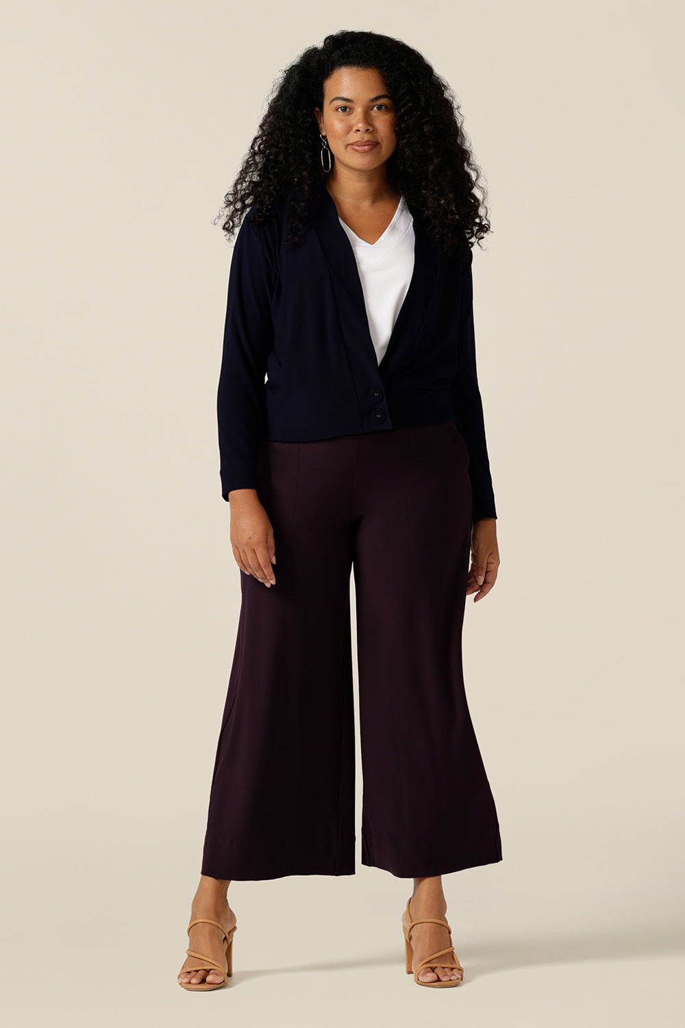 size 12 curvy woman wears a V-neck jersey cardigan in navy blue with long sleeves. Great for Australian and New Zealand woman looking a jacket for autumn/winter, this jacket-cardigan hybrid works for corporate and casual wear.