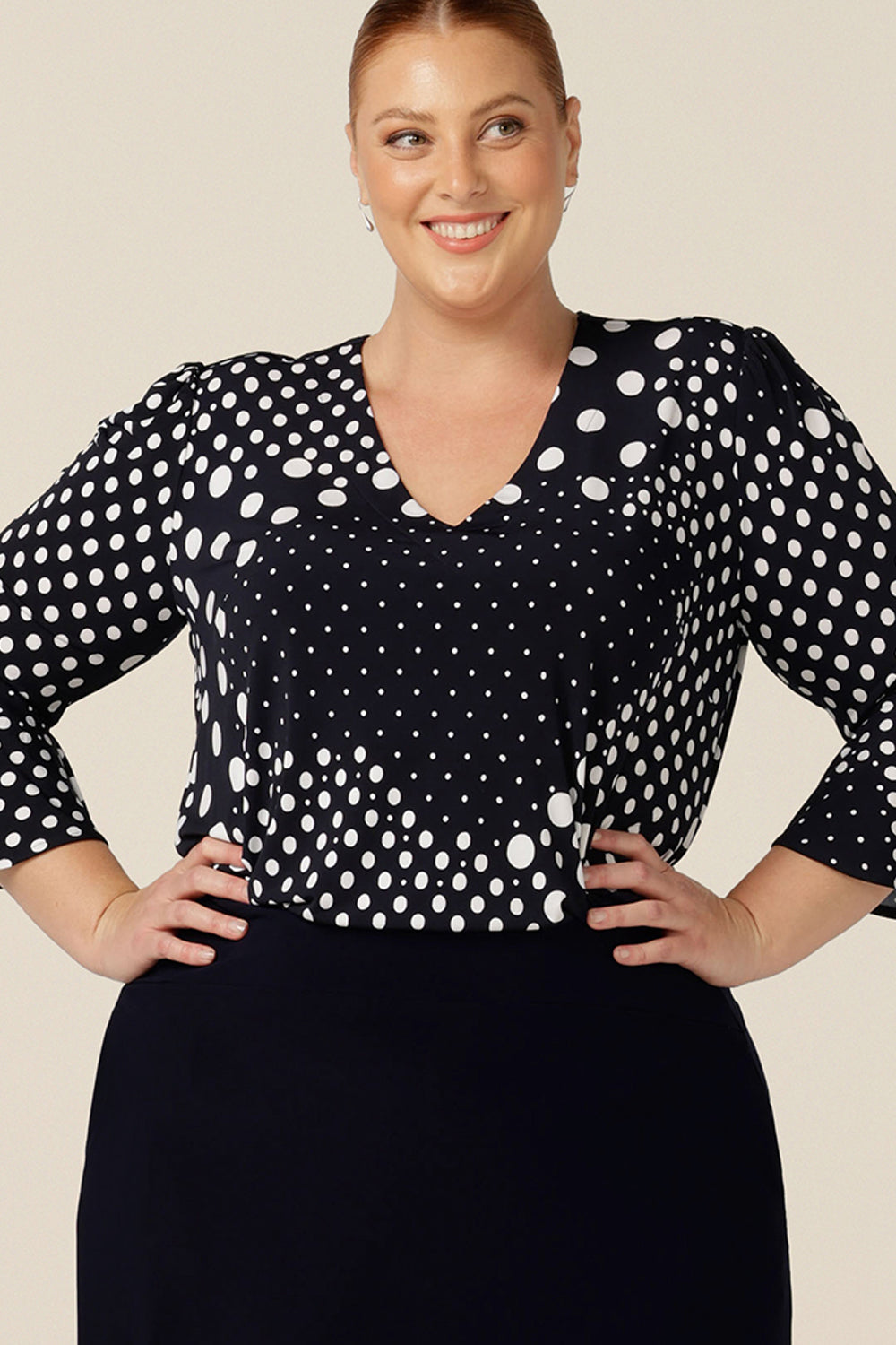 A chic top for plus size and fuller figure women, this V-neck top with fluted 3/4 sleeves comes in a navy and white spot print.
