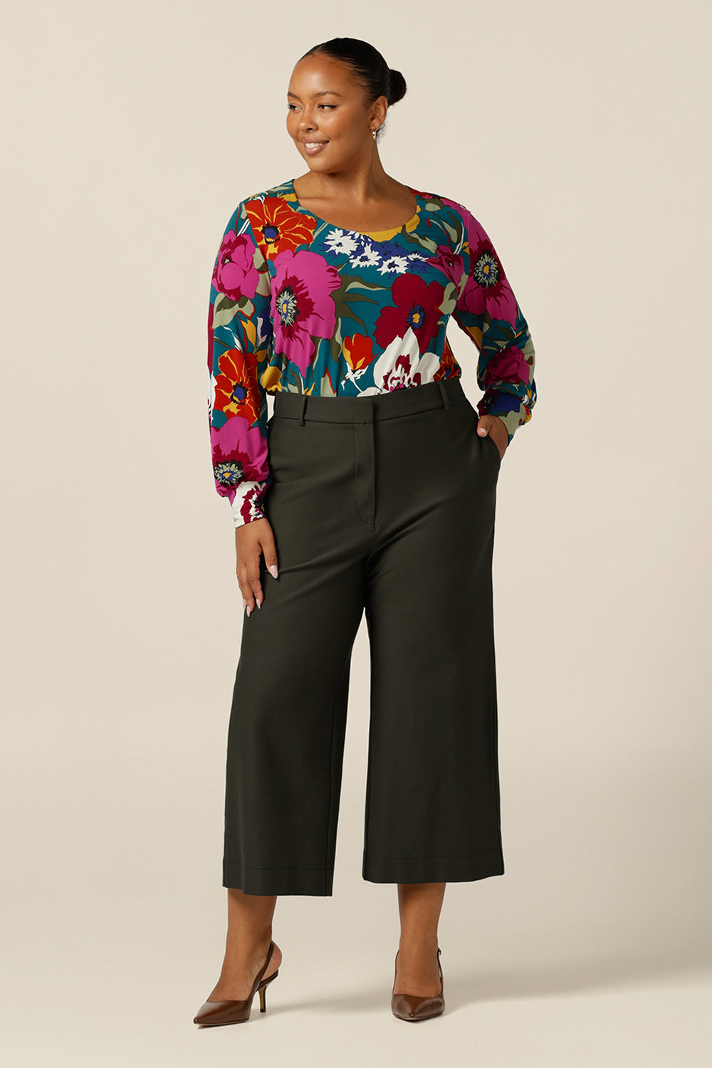  A size 18, plus size woman wears these wide leg, cropped and tailored workwear trousers with floral print long sleeve top. Great for work and casual wear, these  made-in-Australia pants promise comfort and quality.