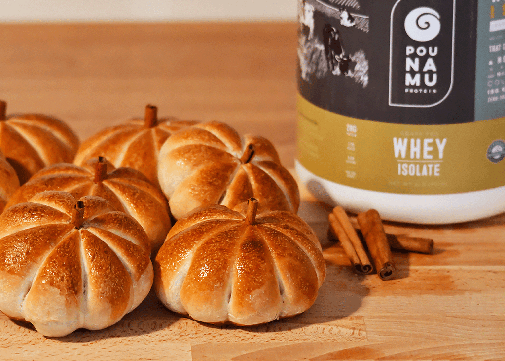 Golden pumpkin shaped dinner rolls with a container of Pounamu Protein Whey Isolate 