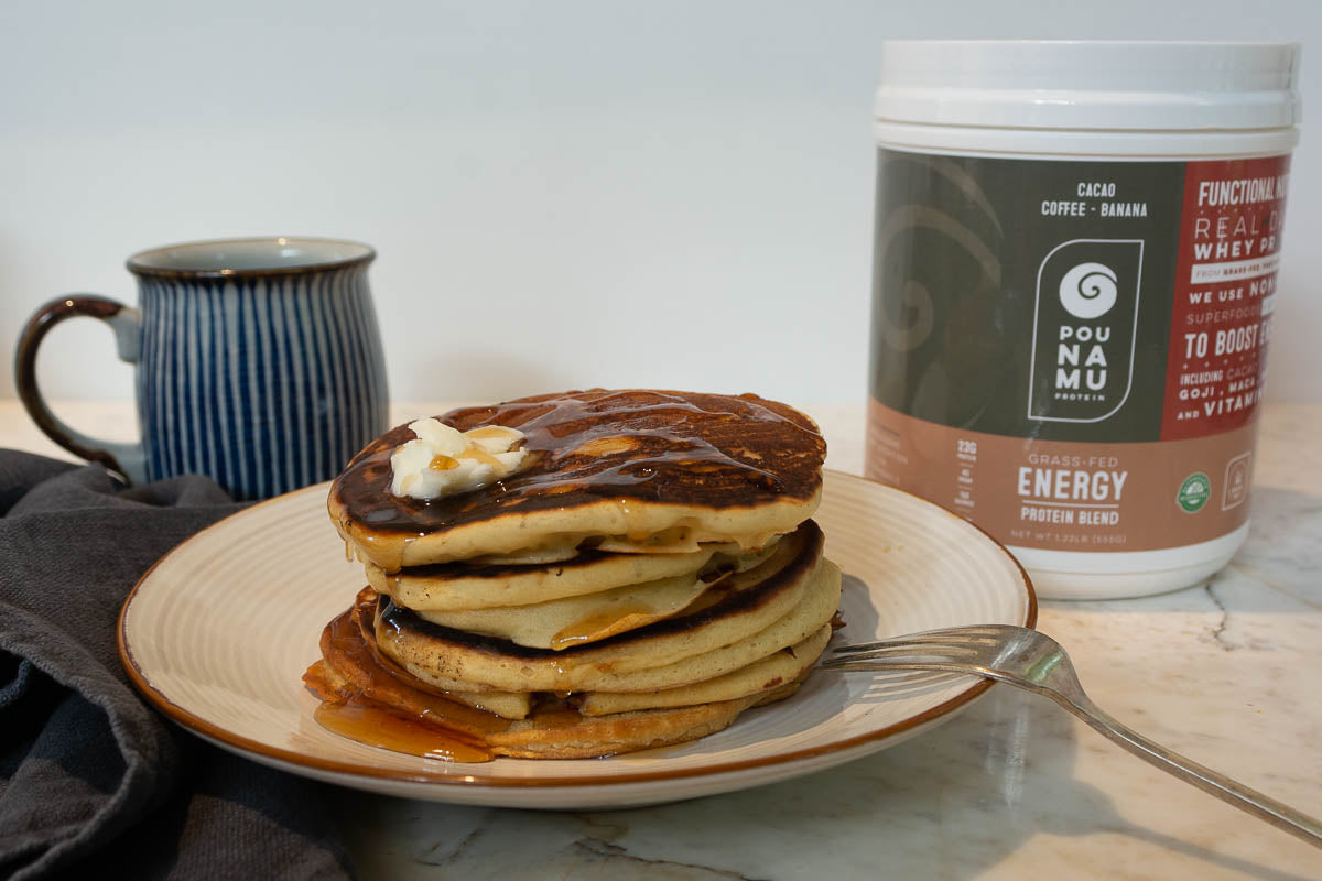 Protein pancakes with maple syrup and butter on top with Pounamu Protein Energy blend container in the background.