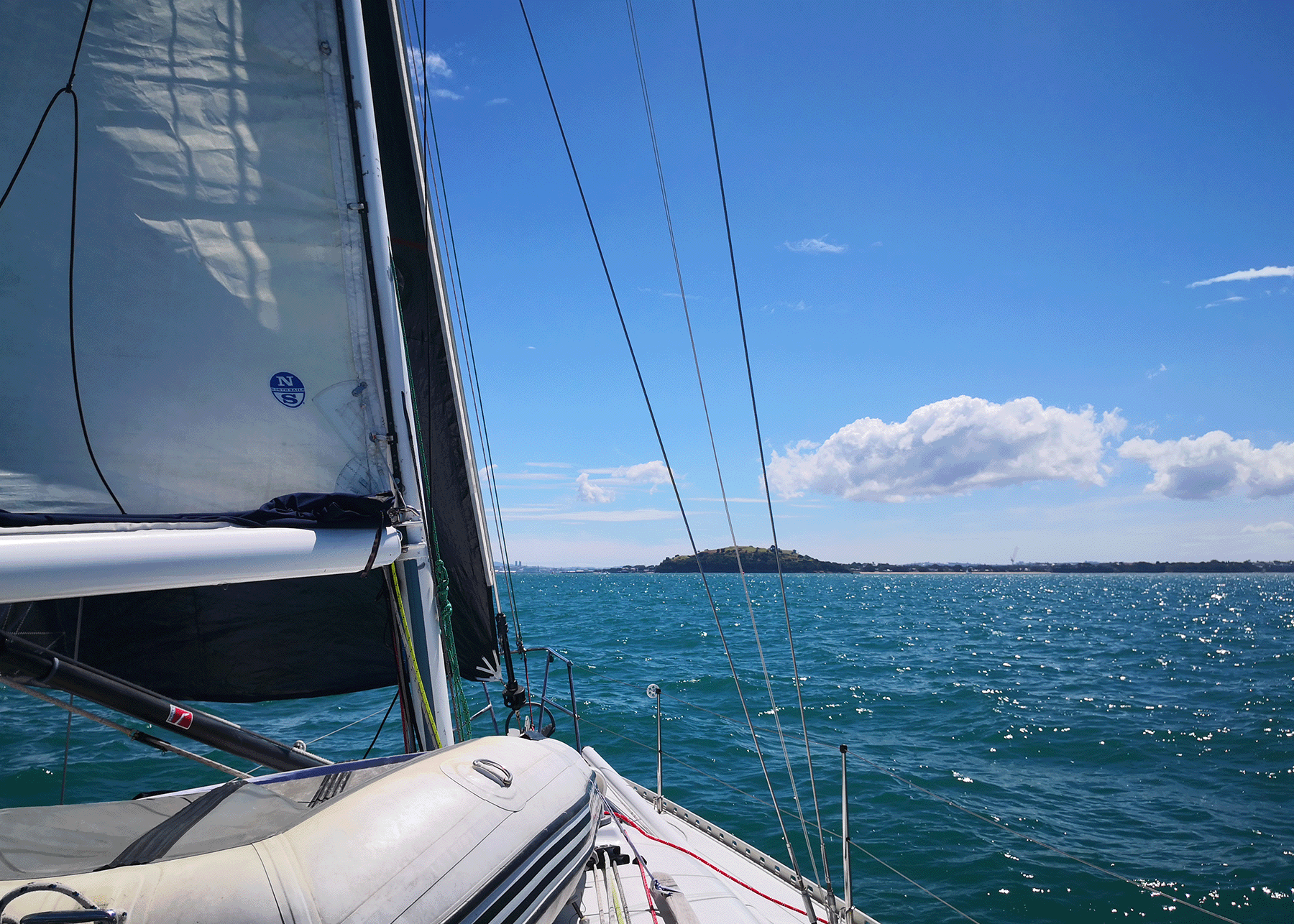 Looking forward to the bow while sailing in perfect conditions with sunshine and blue skies.