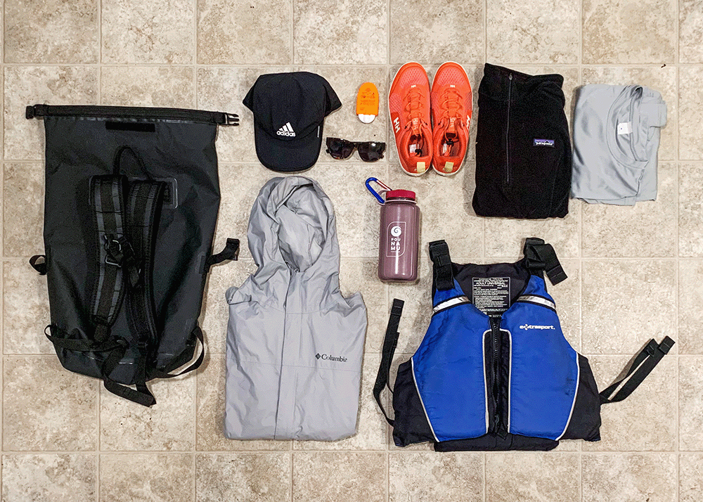 Flat lay of sailing essentials including Pounamu Protein water bottle, dry bag, jacket, sunscreen, life jacket, sunglasses, sunscreen, sailing shoes, hat, fleece and rash vest.