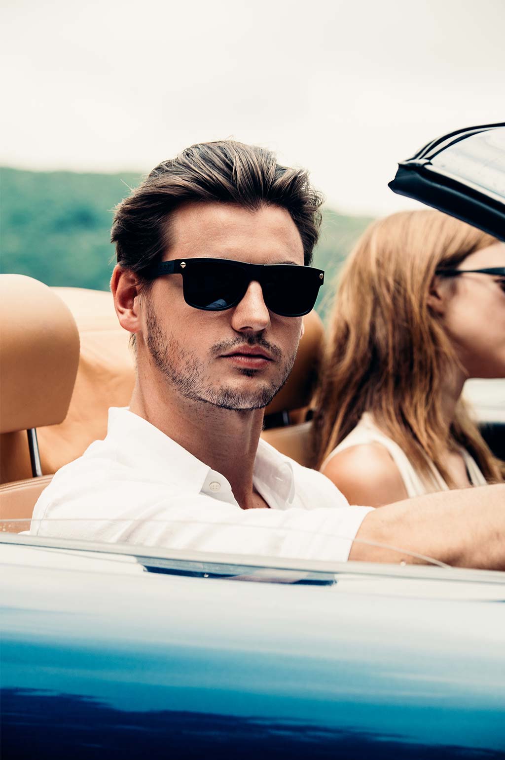 Male and Female model wearing Baendit sunglasses in a car 