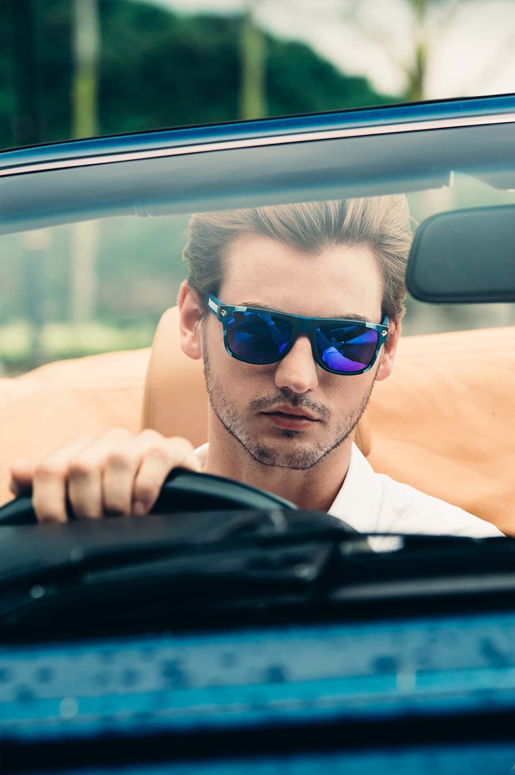 Male model wearing Baendit Sunglasses in a sports car