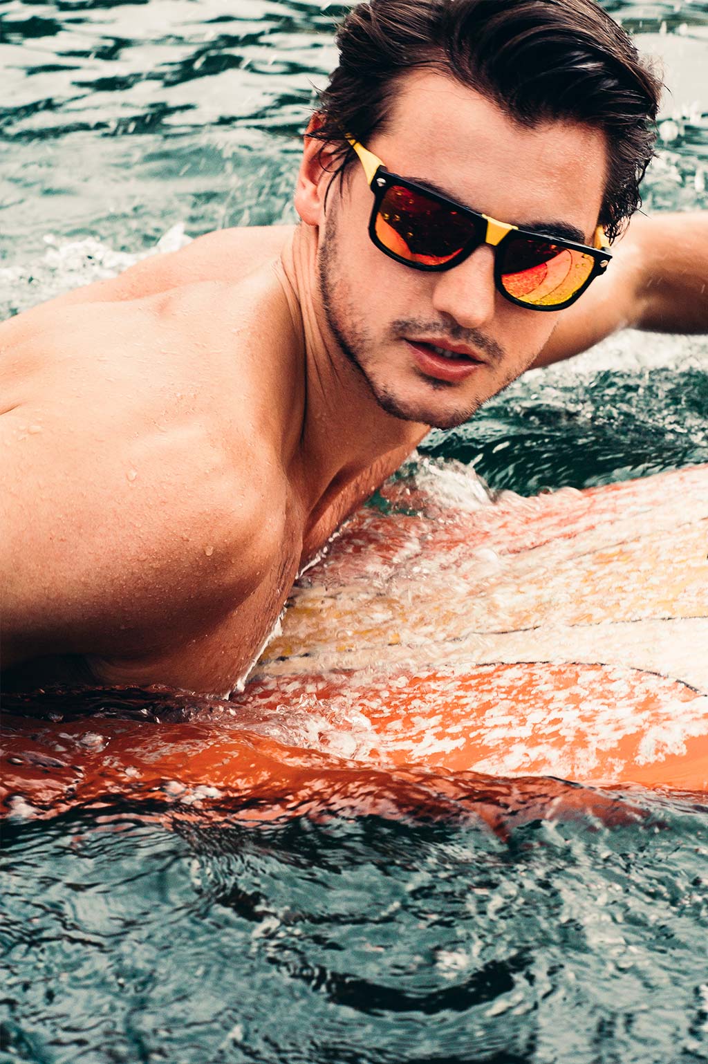 Male model wearing Baendit on a surfboard