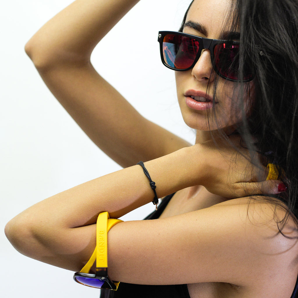 Female model wearing a pair of Baendit sunglasses on wrist and head