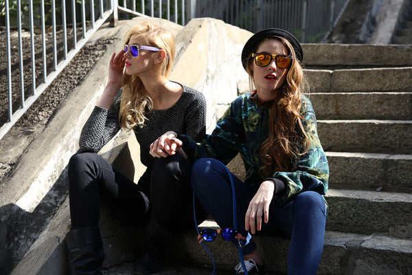 two models sitting wearing sunglasses