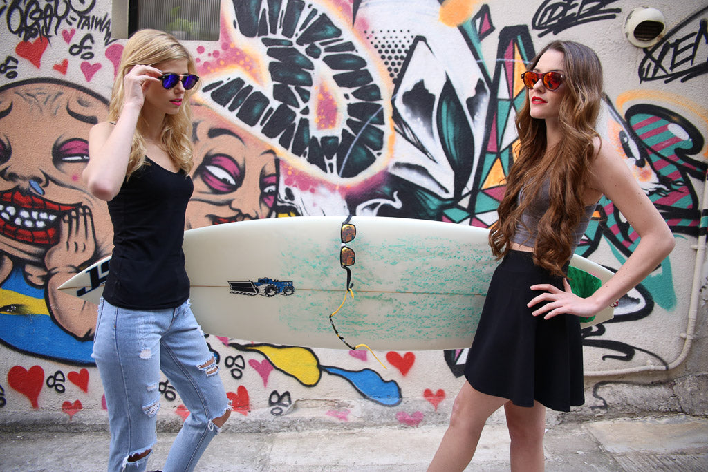 two female models holding surfboard wearing Baendit sunglasses