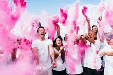 Family in a cloud of pink smoke from gender reveal