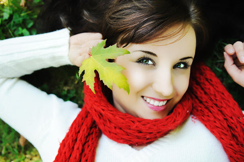 girl with glowing skin while holding a leaf