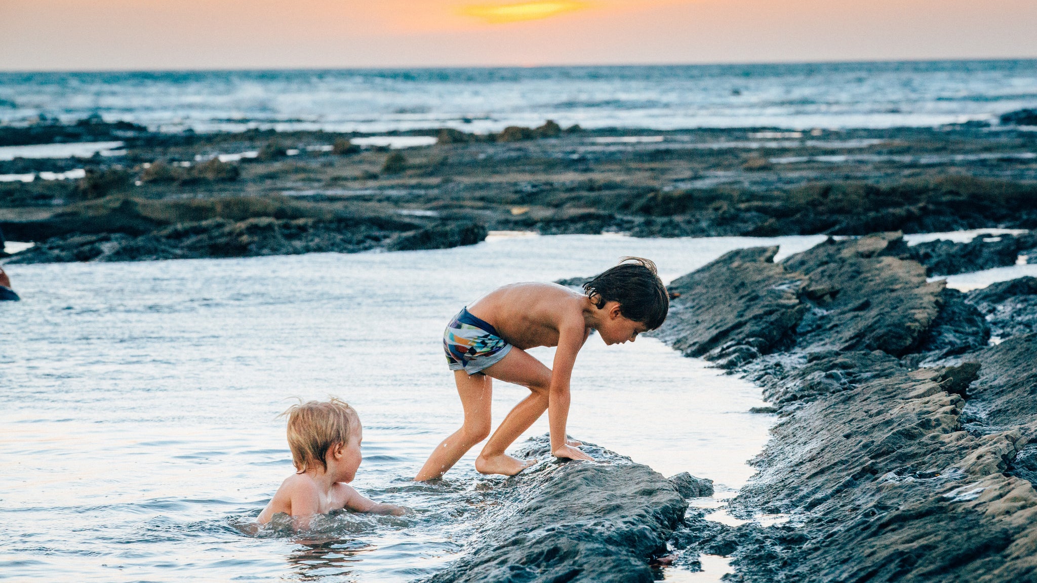 boys swimming in the ocean tidal pools
