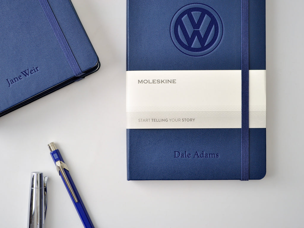 Moleskine Classic hardcover notebook in navy sapphire blue with custom embossed Volkswagen logo imprint