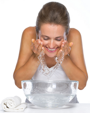 Female splashing water on her cleansed face