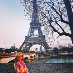 Lottie doll in Paris with the Eiffel Tower in the background