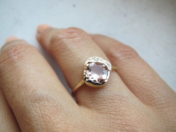 Yellow gold with reflective morganite gemstone on model's hand 