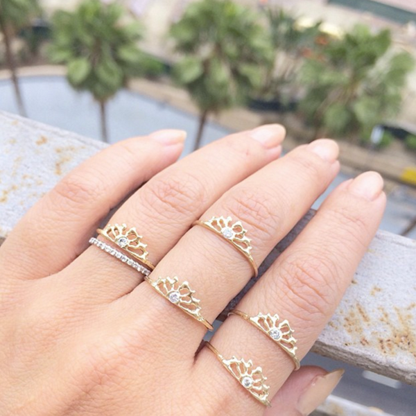 5 handcrafted yellow gold rings on model's hand 