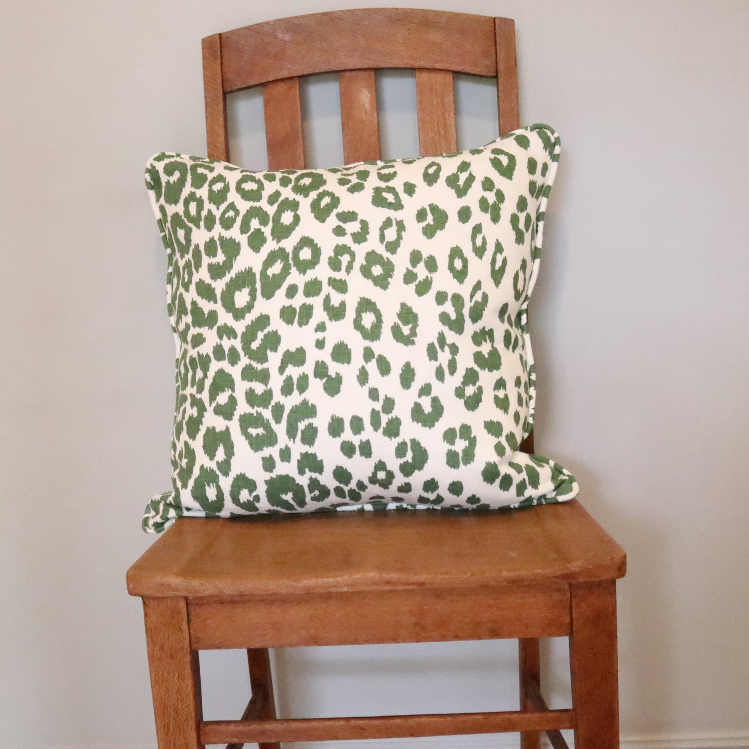 Front view: This stunning scatter cushion features Schumachers 'Iconic Leopard' print in green on the front & piping,  with a gorgeous green back (striking in its own right).   Handmade to the highest standards, with all raw edges overlocked, a quality zipper & feather insert this pillow will last a lifetime and make a spectacular addition to your home. 