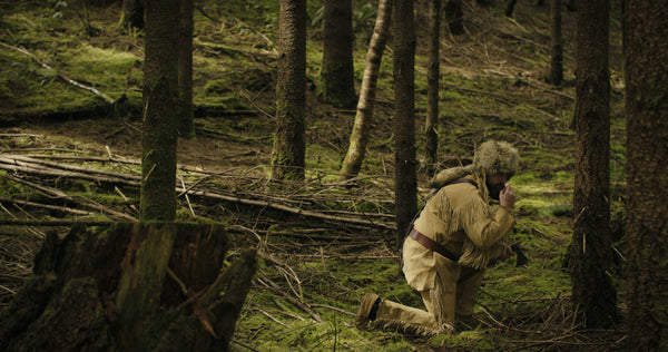 Old Trapper Kneeling in the Forest