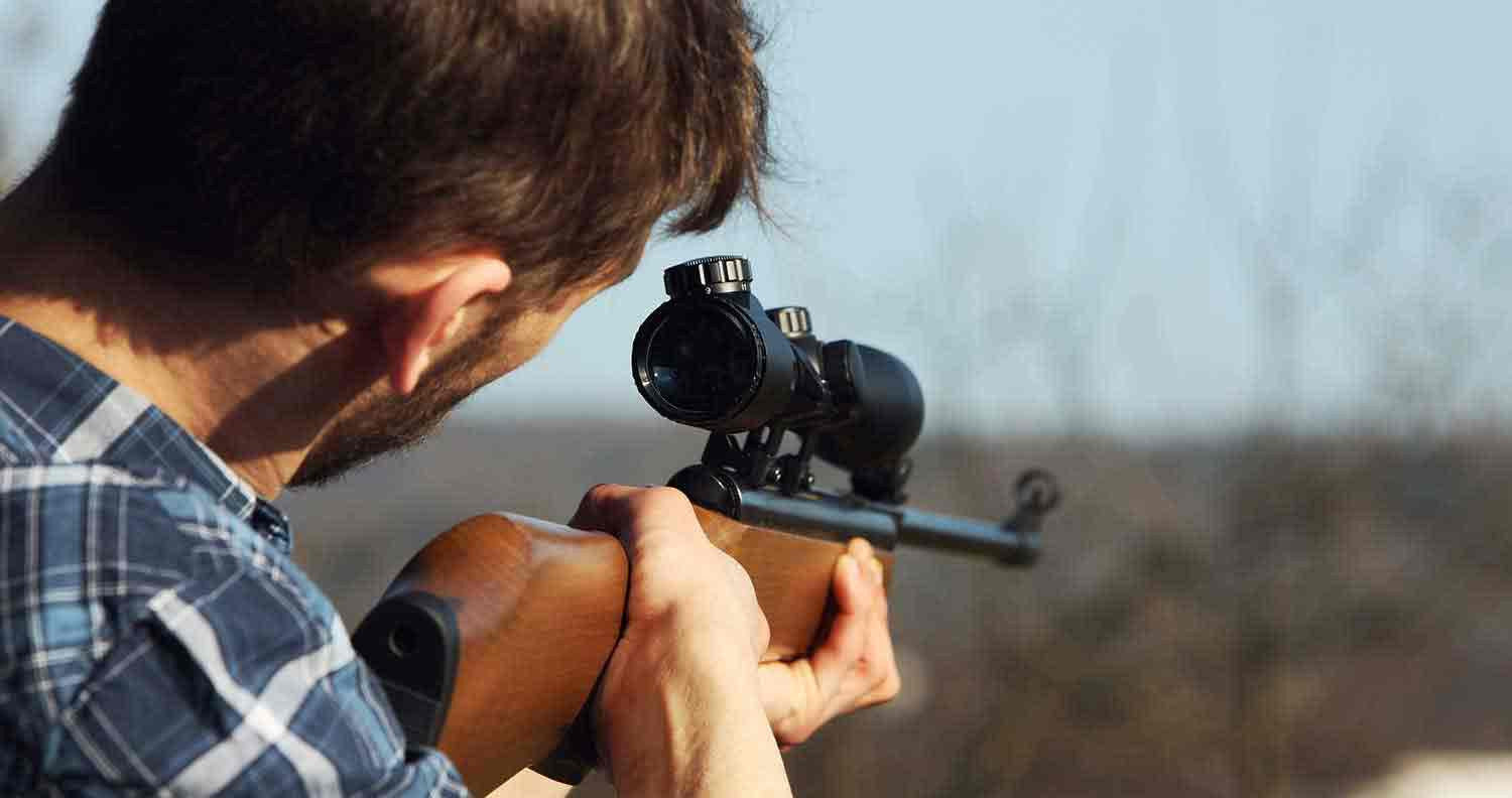 Man using scope on rifle