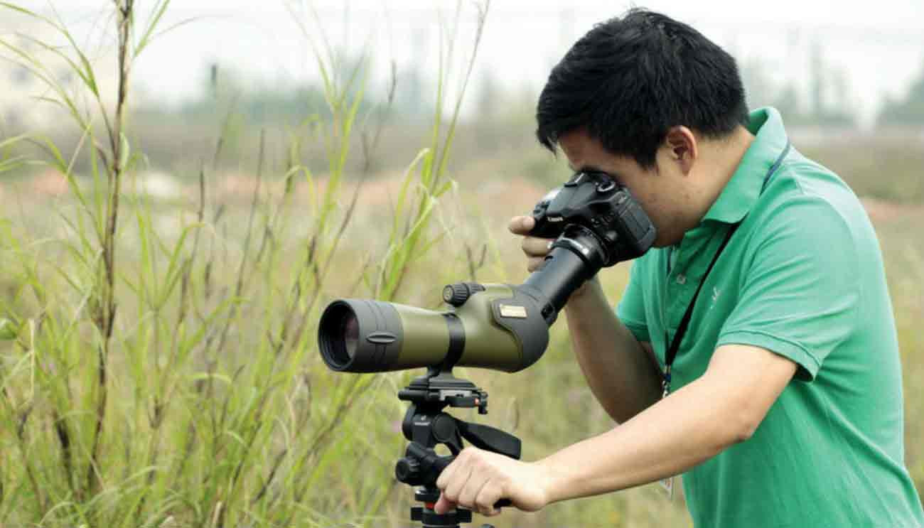 Man using tripod with spotting scope