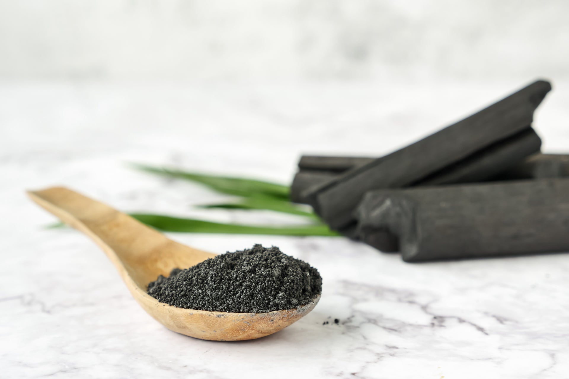 activated charcoal in a spoon sitting on a marble countertop