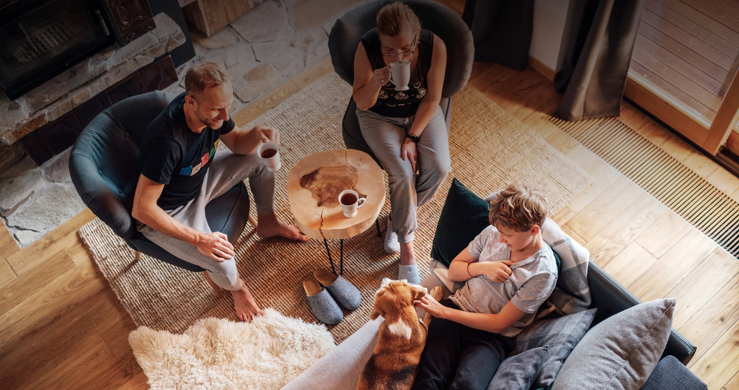 Family drinking amazing coffee brewed from Perth's best coffee beans in their lounge room. Mum, dad, child and dog are all happy