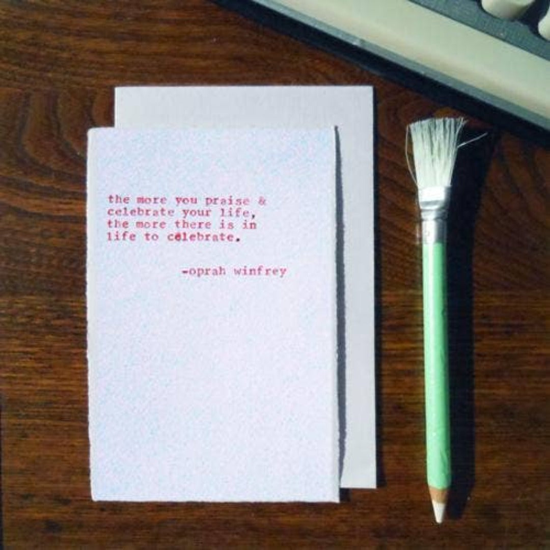A white envelope and card reading in red "the more you praise & celebrate your life, the more there is in live to celebrate by oprah winfrey.